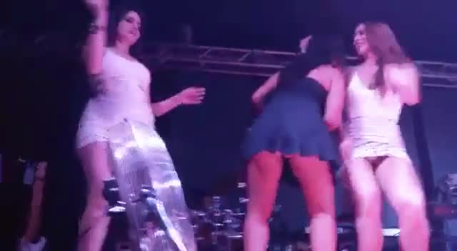 Flagra 3 mulheres no grau dançando de vestido no festival de musica